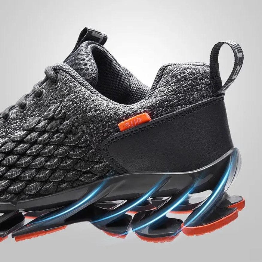 Grauer Sportschuh mit schwarzer Sohle, Mesh-Obermaterial, orange Details, futuristisches Design.