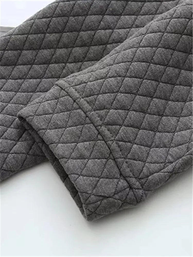 Grauer, gesteppter Stoff, Detailansicht, weiches Material, Textil, Mode, Bekleidung.