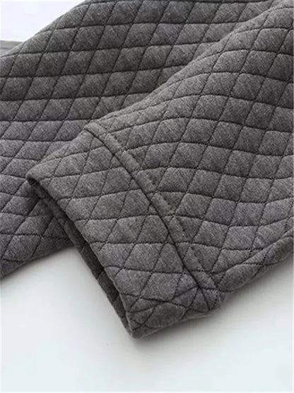 Grauer, gesteppter Stoff, Detailansicht, weiches Material, Textil, Mode, Bekleidung.