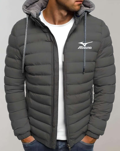 Mann in grauer Mizuno-Daunenjacke mit Kapuze, weißem T-Shirt und blauer Jeans.