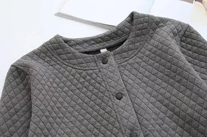 Graue gesteppte Jacke mit Rundhalsausschnitt und Druckknöpfen, modisch und warm.