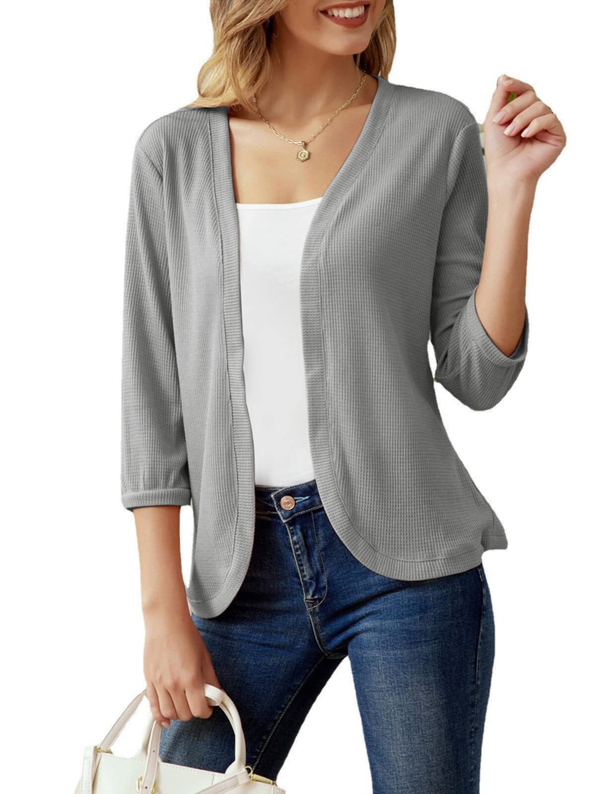 Frau trägt grauen Cardigan, 3/4-Ärmel, über weißem Top, lässiger Look, Mode für Damen.