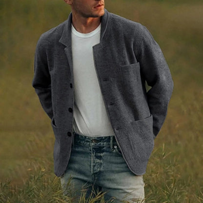 Mann in grauem Wollblazer und weißem T-Shirt, lässig in Natur stehend, Mode für Herren.