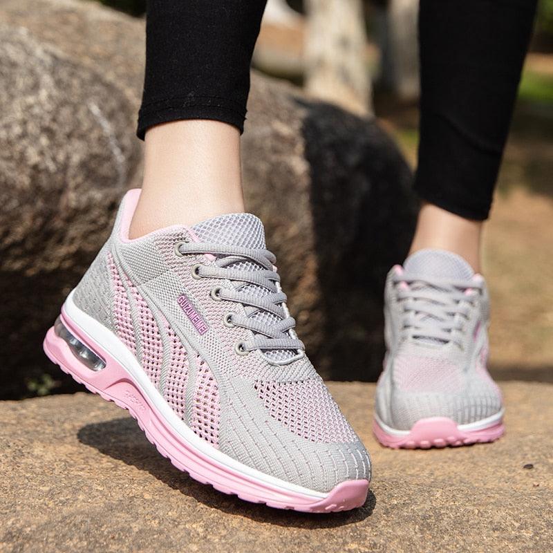 Graue und rosa Damen-Sneaker, atmungsaktiv, mit Luftpolstersohle, ideal für Laufen und Freizeit.