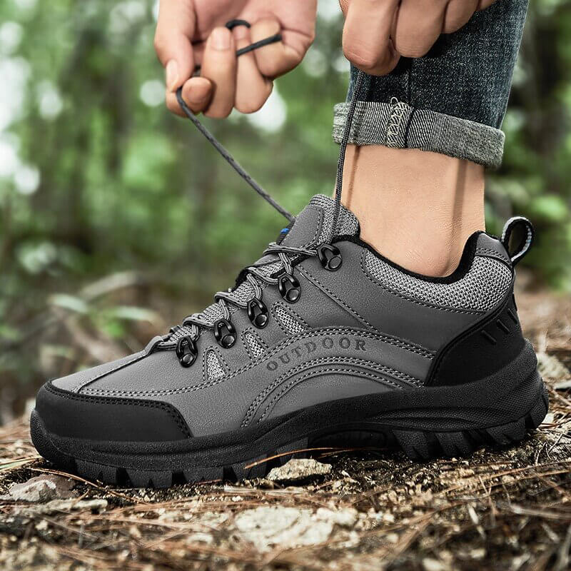 Grauer Outdoor-Wanderschuh, robust, rutschfest, ideal für Trekking im Wald.