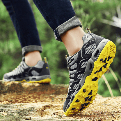 Graue Outdoor-Wanderschuhe mit gelber Sohle, atmungsaktiv, ideal für Trekking und Abenteuer.