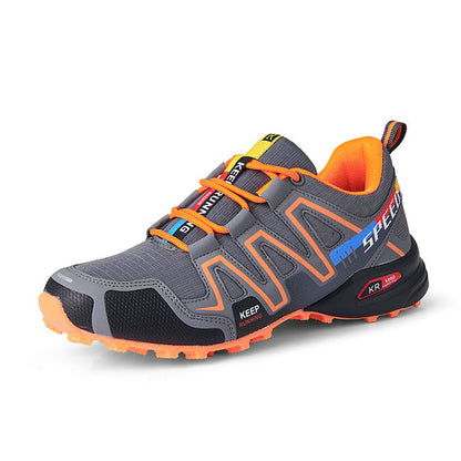 Grauer Wanderschuh mit orangefarbenen Akzenten, atmungsaktiv, rutschfeste Sohle, Outdoor-Sport.