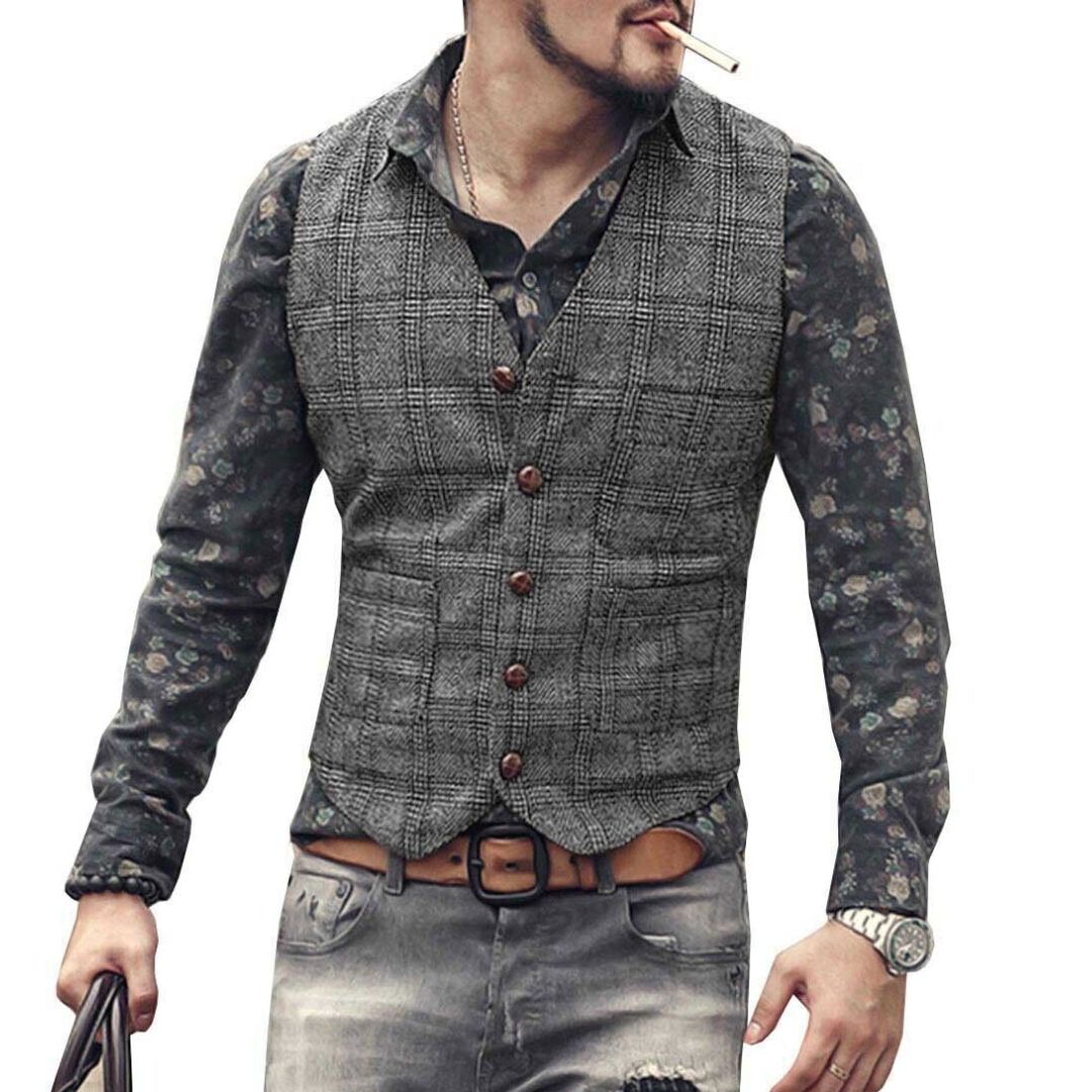 Mann mit grauer karierter Weste, Blumenhemd, Jeans, Uhr, Zigarette, modischer Herrenstil.