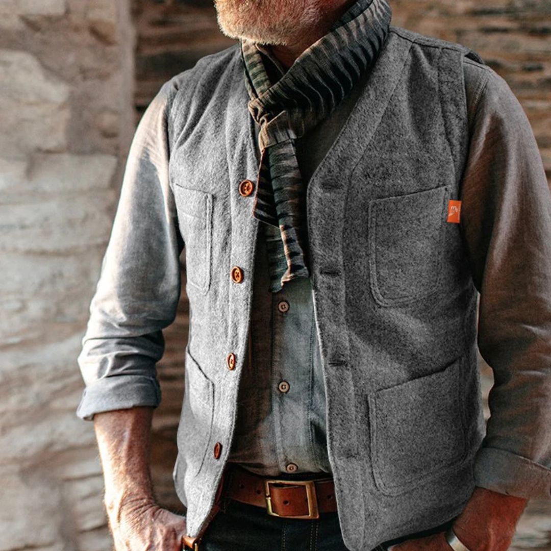 Graue Herrenweste aus Wolle mit Holzknöpfen, kombiniert mit gestreiftem Schal, lässiger Look.
