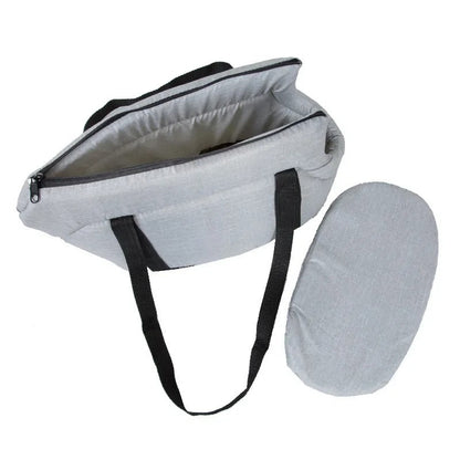 Graue Wickeltasche mit schwarzen Trägern und passender Wickelunterlage, ideal für unterwegs.