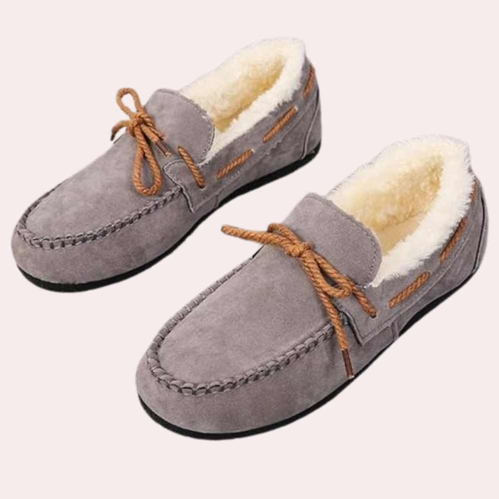 Graue Wildleder-Hausschuhe mit Fellfutter und braunen Schnürsenkeln, gemütliche Wintermode.