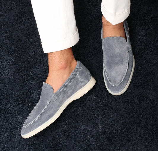 Graue Wildleder-Loafers für Herren, stilvoll und bequem, auf dunklem Teppich.