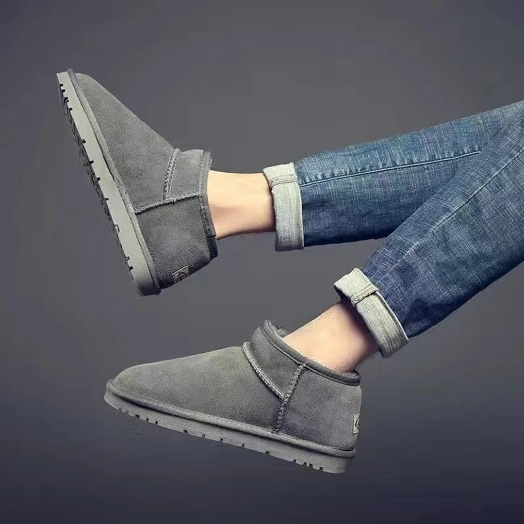 Graue Winterstiefel aus Wildleder, knöchelhoch, mit Jeans kombiniert, modisch und warm.