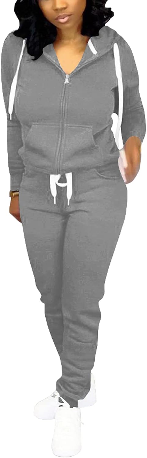 Frau in grauem Kapuzenpullover-Trainingsanzug mit weißen Schnürsenkeln und weißen Turnschuhen.