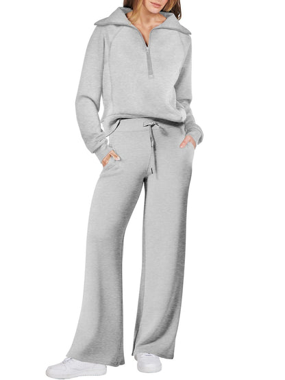 Frau in grauem Jogginganzug, Reißverschluss, weite Hose, Freizeitmode, bequeme Kleidung.