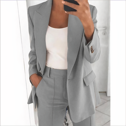 Frau im grauen Anzug mit weißem Top, Businessmode, elegante Damenbekleidung, Bürooutfit.
