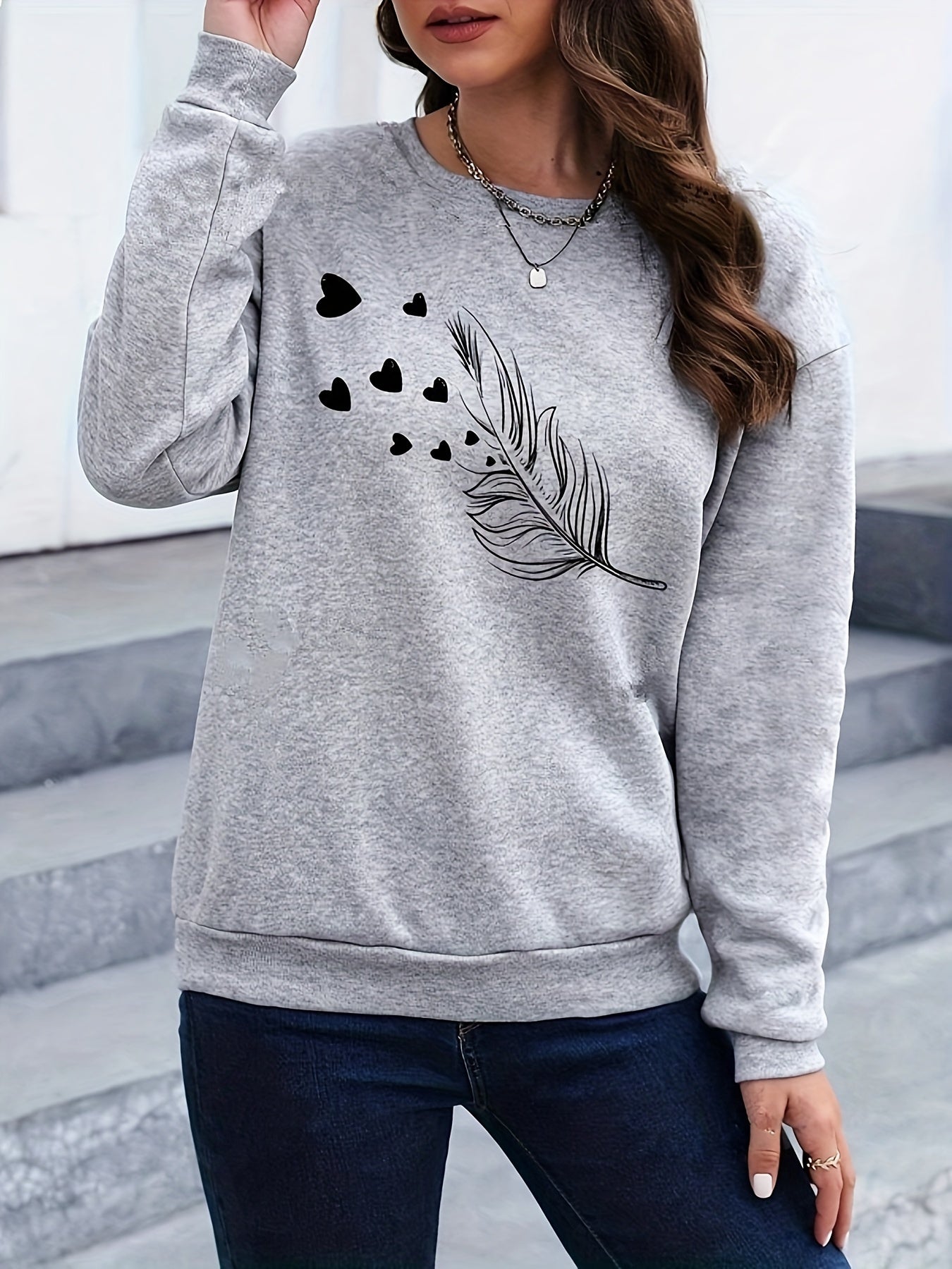 Grauer Damenpullover mit schwarzem Feder- und Herzmotiv, lässig, Baumwolle, modisch.