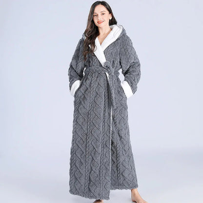 Frau im grauen, langen, flauschigen Bademantel mit Kapuze und Gürtel, gemütliche Wintermode.