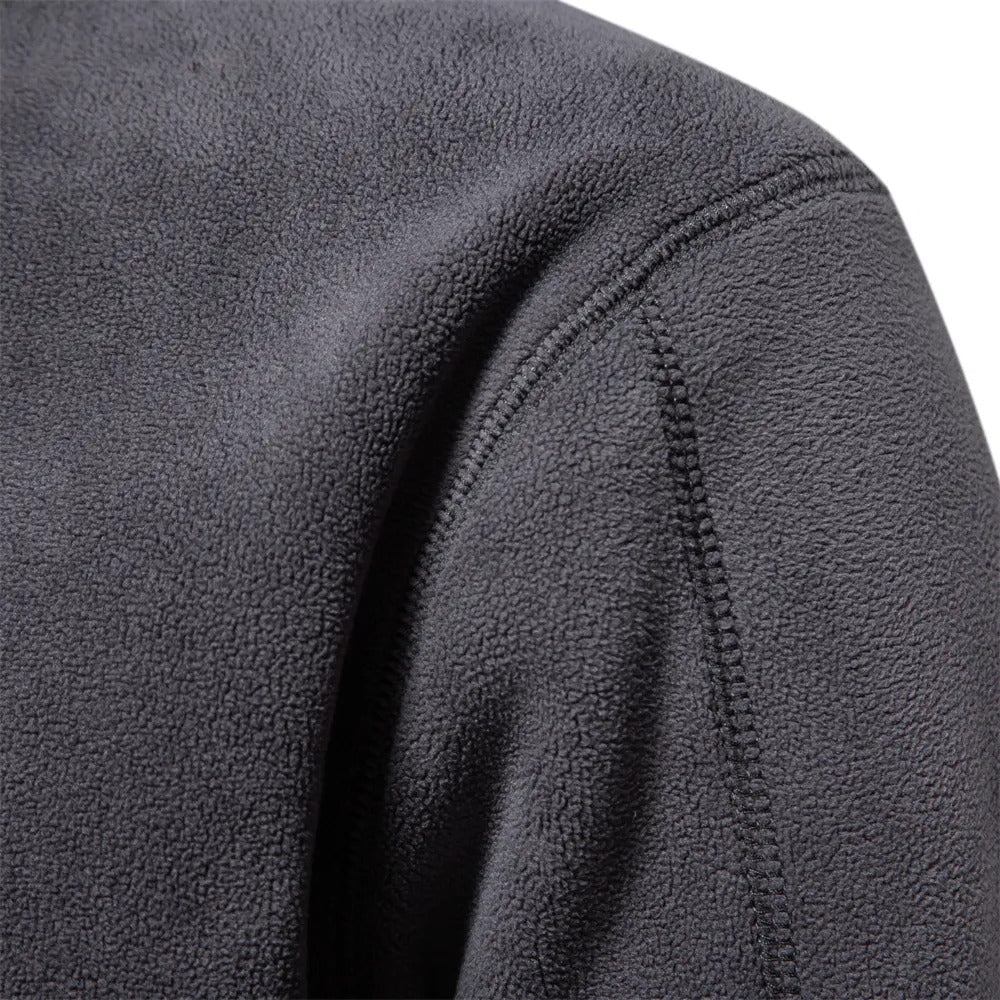 Dunkelgraue Fleecejacke, Nahaufnahme, weiches Material, Outdoor-Bekleidung, warm und bequem.