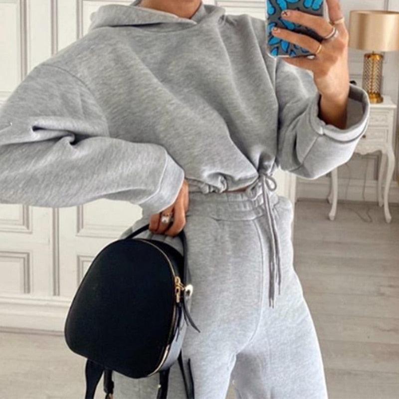 Graues Damen-Sweatshirt und Jogginghose Set, Kapuze, Freizeitmode, mit schwarzem Rucksack.
