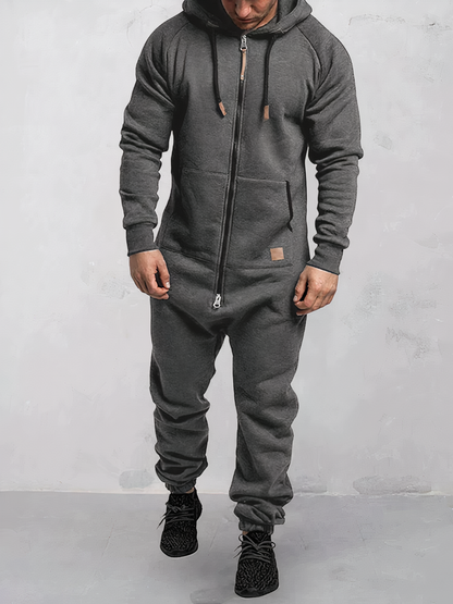 Mann in grauem Einteiler-Jumpsuit mit Kapuze, Reißverschluss, Freizeitmode, bequem, modern.