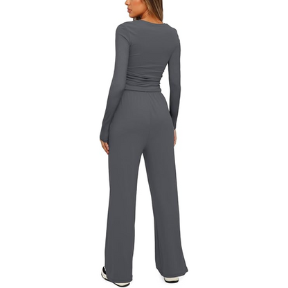 Frau in grauem, langärmligem Jumpsuit, Rückansicht, modisch, bequem, Freizeitkleidung.