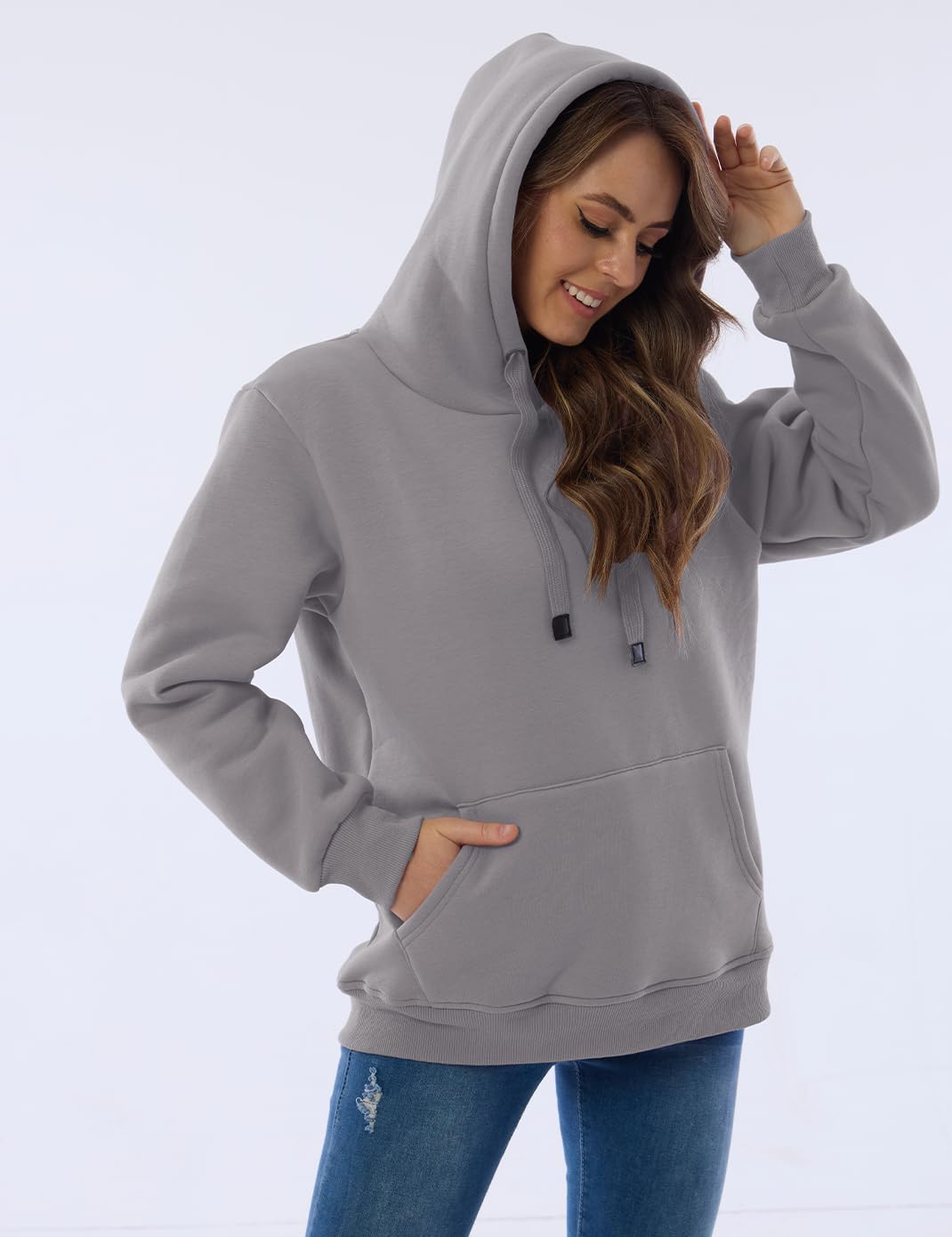 Frau in grauem Kapuzenpullover, lässig, modisch, bequem, Freizeitkleidung, Jeans.