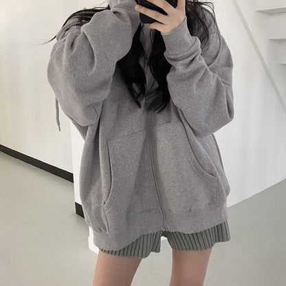 Frau in grauem Kapuzenpullover, lässiger Stil, modische Freizeitkleidung, Selfie.