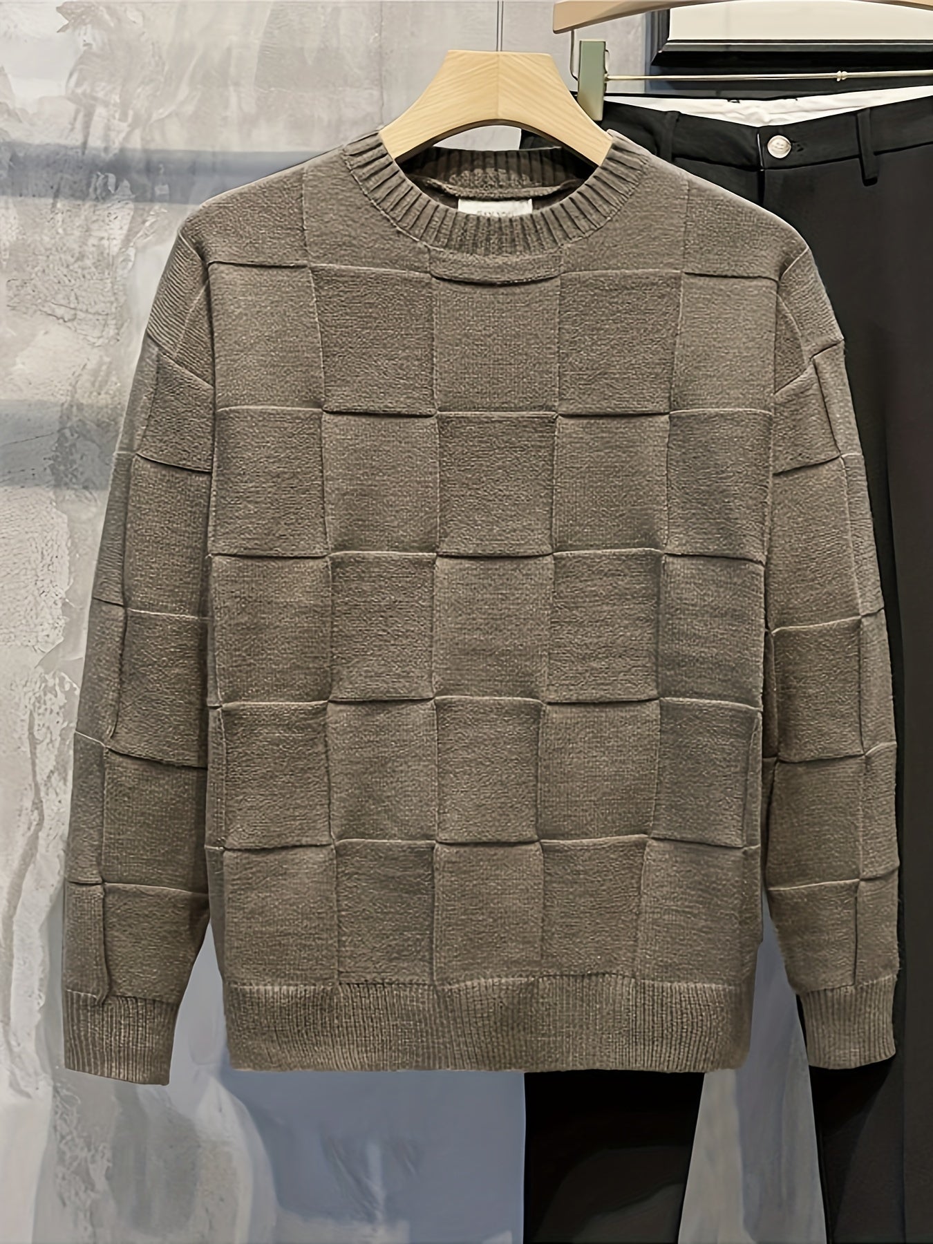 Grauer Strickpullover mit Karomuster, Herrenmode, Baumwolle, Herbst-Winter, auf Kleiderbügel.