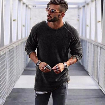 Mann mit schwarzem Pullover, Sonnenbrille und Armbändern auf Brücke, modischer Herrenstil.