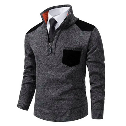 Grauer Herrenpullover mit Reißverschluss, schwarzem Schulterdetail und Brusttasche.