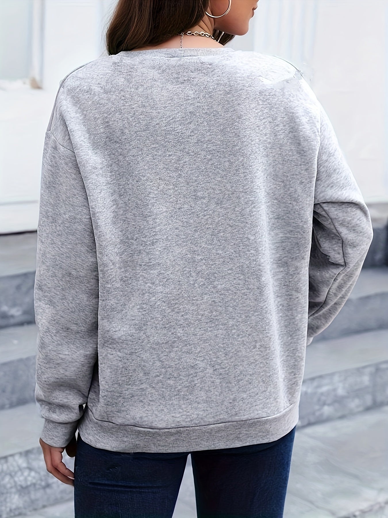 Frau in grauem Sweatshirt, Rückansicht, lässige Mode, Herbstkleidung, urbaner Stil.