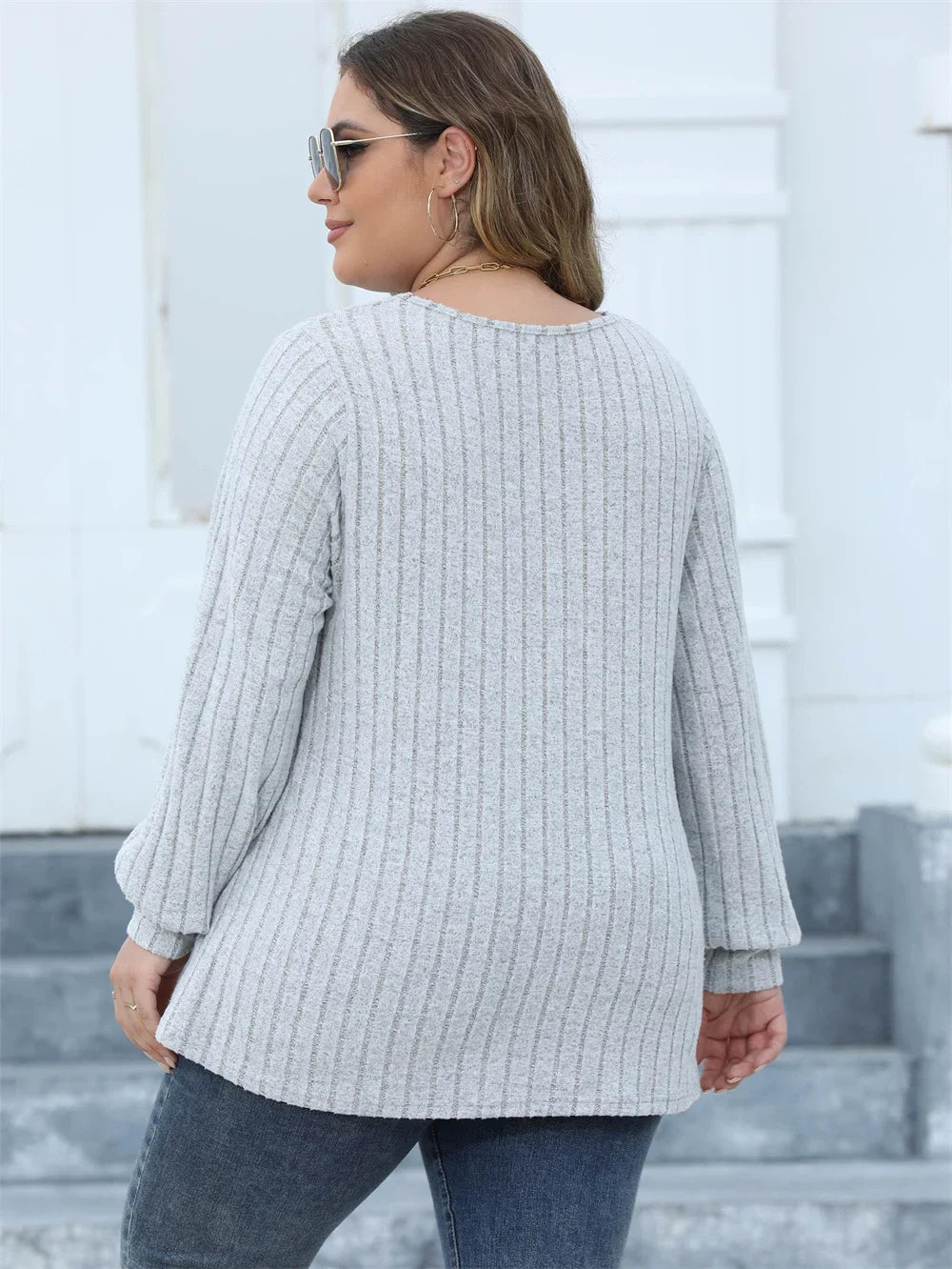 Frau in grauem Strickpullover, Plus-Size-Mode, Herbstmode, lässiger Stil, Rückansicht.