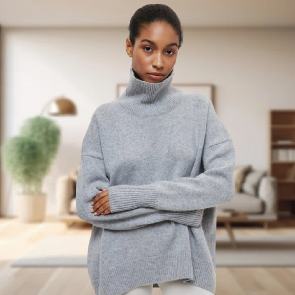 Frau in grauem Rollkragenpullover aus Wolle, gemütliches Wohnzimmer, moderne Einrichtung.