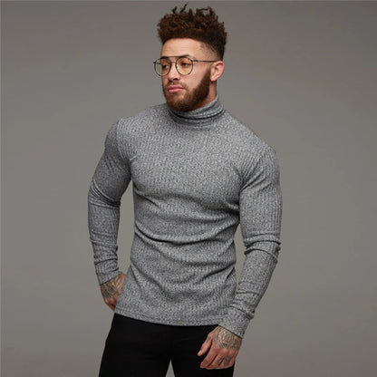 Mann in grauem Rollkragenpullover, Brille, tätowiert, modisch, stilvoll, Herbstmode.