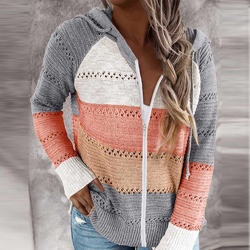 Frau trägt gestreifte Strickjacke mit Kapuze in Grau, Weiß, Rosa und Orange, lässiger Stil.