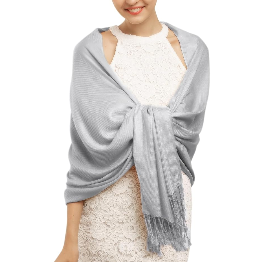Frau mit grauem Schal aus Kaschmir über weißem Spitzenkleid, elegantes Modeaccessoire.