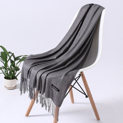 Grauer Kaschmirschal auf weißem Stuhl, weiches Material, modisches Accessoire, Wohnzimmer.
