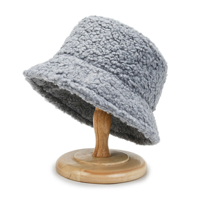 Grauer Damen-Bucket-Hut aus Fleece auf Holzständer, modisch und warm.
