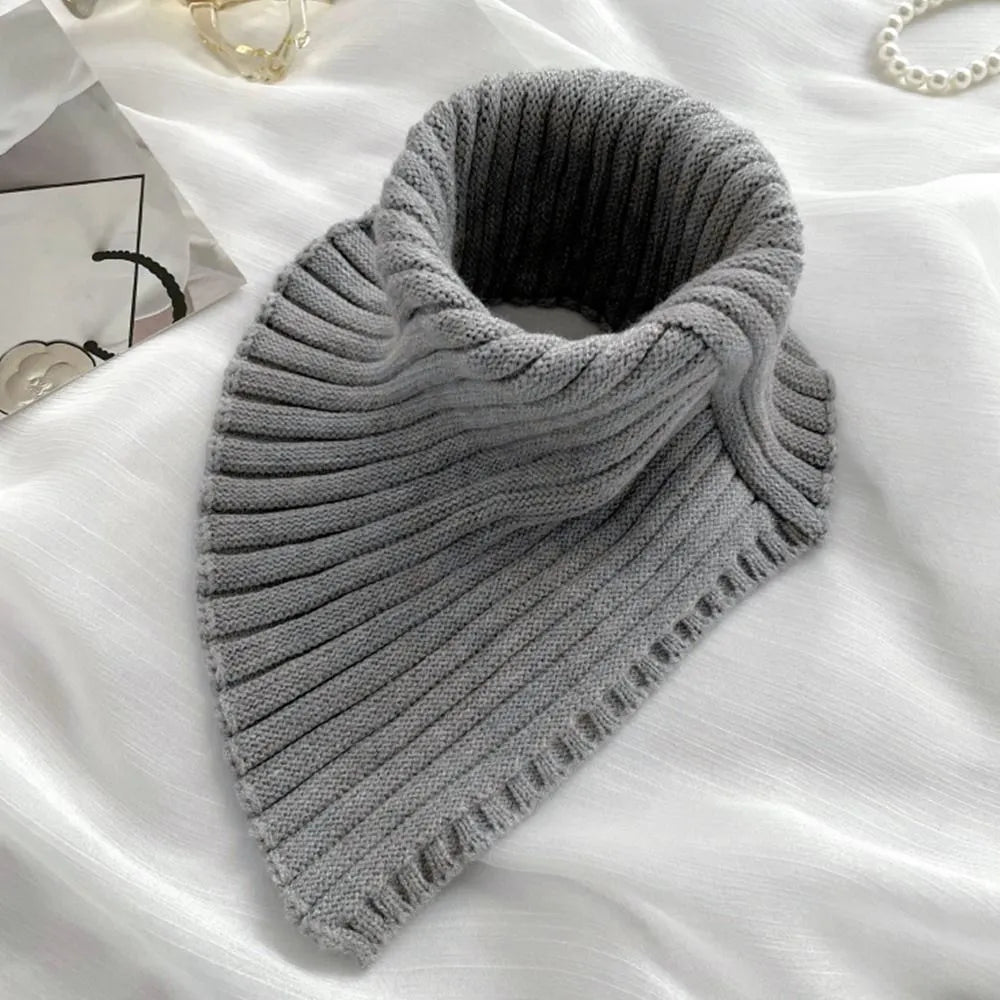 Grauer Strickkragen, Rippenmuster, weiches Material, modisches Accessoire für Herbst/Winter.