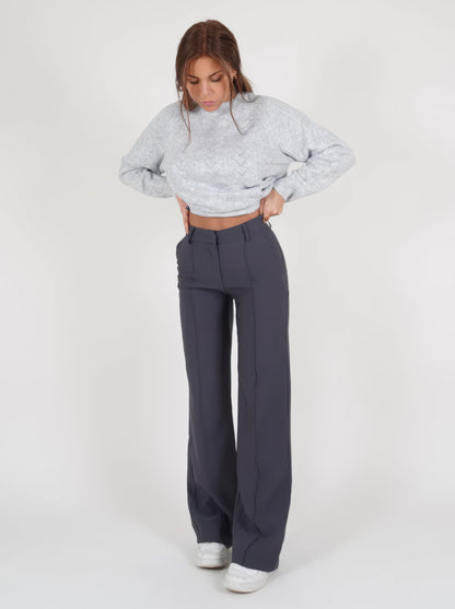 Frau in grauem Strickpullover und dunkelgrauer Hose, modische Damenbekleidung, Wintermode.