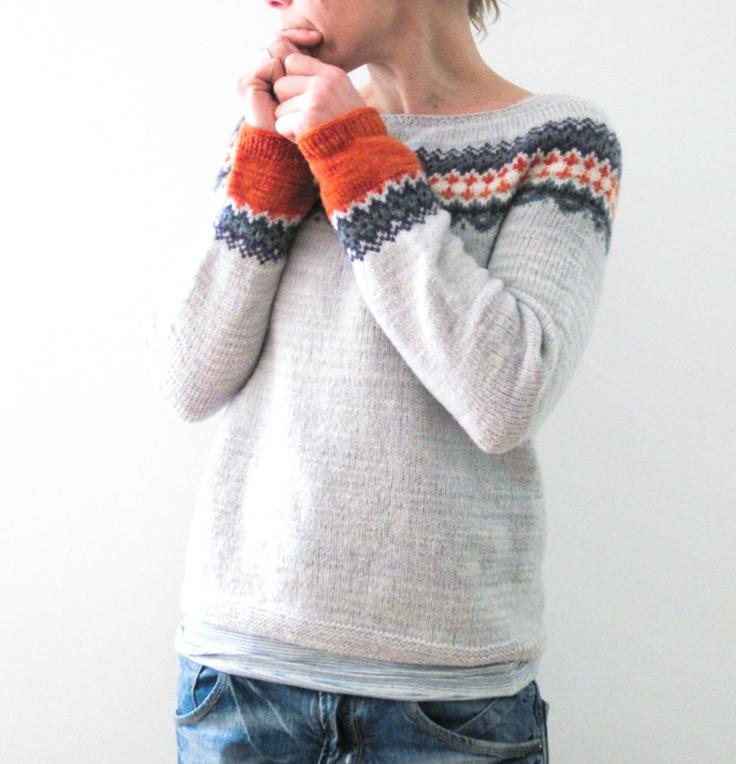 Frau trägt grauen Strickpullover mit buntem Norwegermuster, lässiger Stil, Herbstmode.