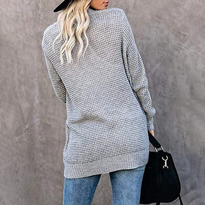 Frau in grauem Strickpullover, Jeans und schwarzem Hut, Rückansicht, lässige Herbstmode.