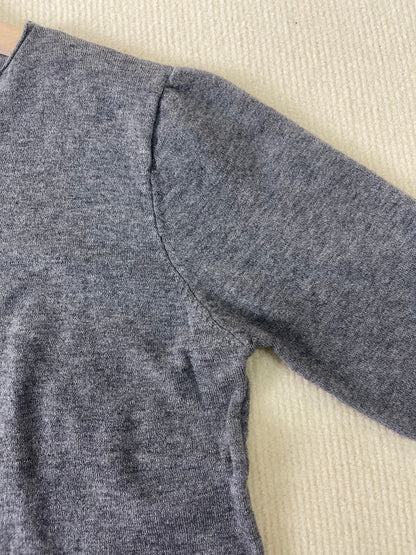 Grauer Wollpullover, Nahaufnahme, weiches Material, langärmeliger Strick, gemütliche Herbstmode.
