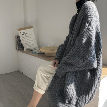 Frau in grauem Strickpullover, gemütlich, modisch, Herbstmode, Innenraum, Tageslicht.