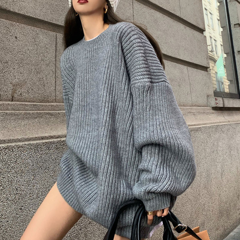 Frau in grauem Strickpullover, Oversize, Herbstmode, urbaner Hintergrund, stilvoller Look.