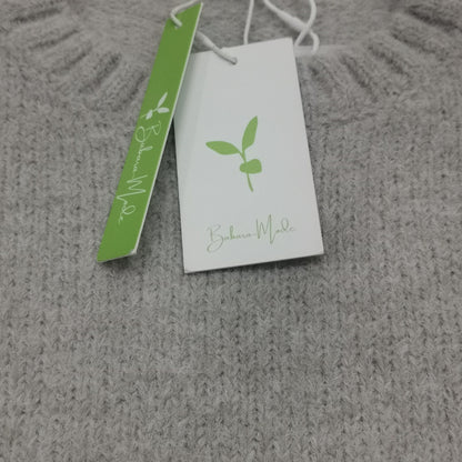 Grauer Strickpullover aus Wolle mit Etikett, nachhaltige Mode, weiches Material, Damenbekleidung.