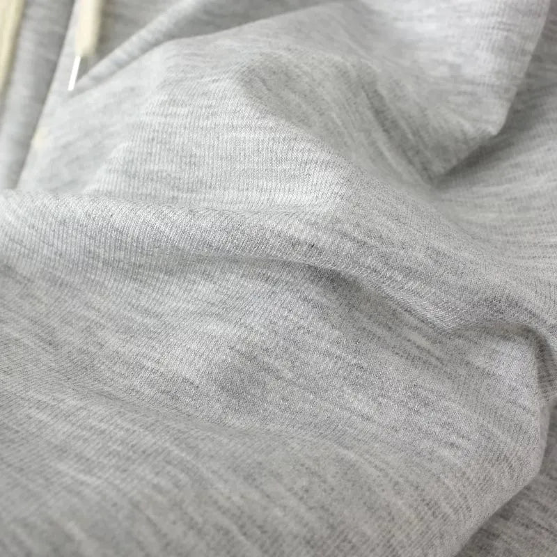 Grauer Baumwollstoff, weiche Textur, ideal für Bekleidung, hochwertiges Material, Nahaufnahme.