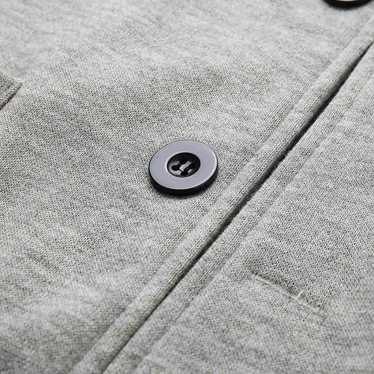Grauer Wollmantel mit schwarzem Knopf, Nahaufnahme, hochwertige Wintermode, stilvoll und elegant.