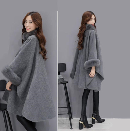 Frau in grauem Wollponcho mit Kunstpelzkragen und -ärmeln, modisch, elegant, Winterkleidung.